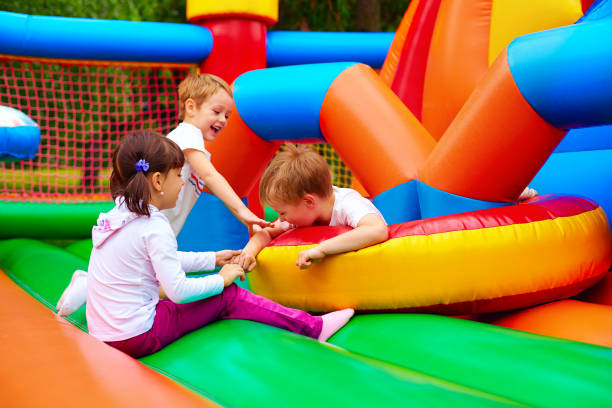 excited kids having fun on inflatable attraction playground - inflatable child playground leisure games imagens e fotografias de stock