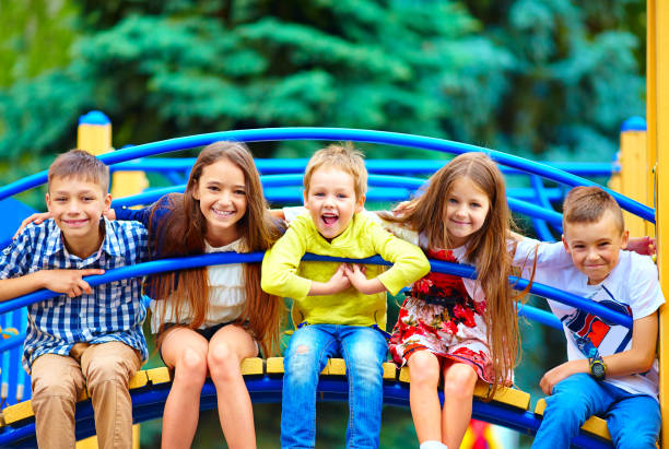 groupe d'enfants heureux ayant l'amusement sur le terrain de jeu - seulement des enfants photos et images de collection