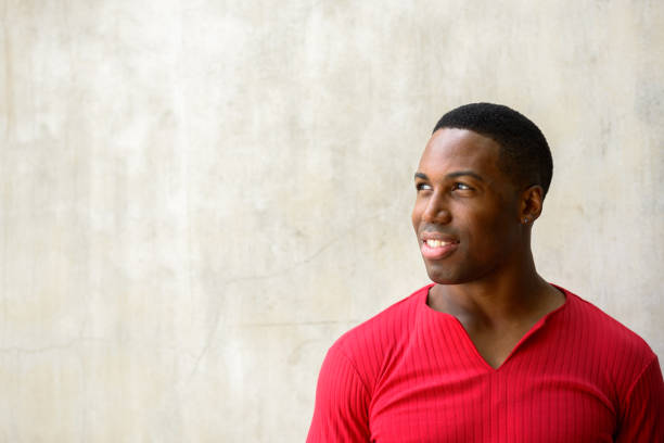 istock Close up of young happy handsome African man smiling while thinking 665009418