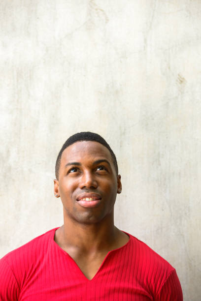 istock Young happy handsome African man thinking and looking up 665009496