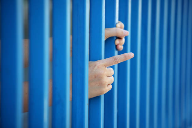 istock hand of prisoner in jail as background. 665009926