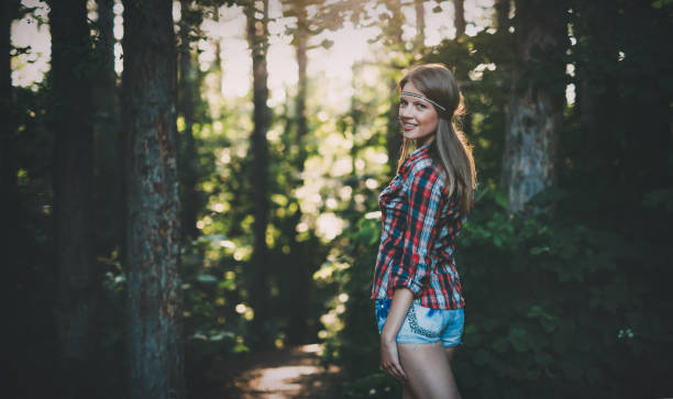 istock Smiling beautiful woman in forest surrounded by trees 665017080