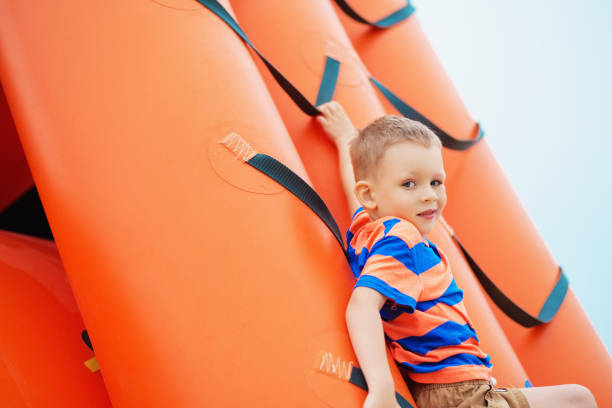 ビーチで膨脹可能な遊び場で遊ぶ少年 - child balloon outdoors little boys ストックフォトと画像