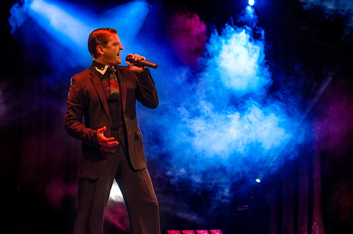 A male nightclub singer on stage