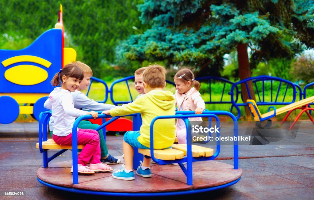 Gruppe von glückliche Kinder, die Spaß am Kreisverkehr am Spielplatz - Lizenzfrei Kinderspielplatz Stock-Foto