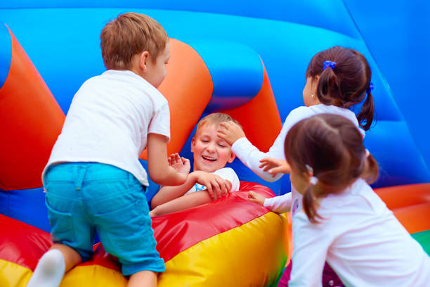 excited kids having fun on inflatable attraction playground - inflatable child playground leisure games imagens e fotografias de stock