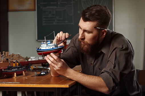 Young man constructing a ship model