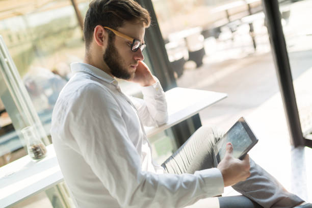 istock Businessman holding mobile device in cafe on business break 665025220