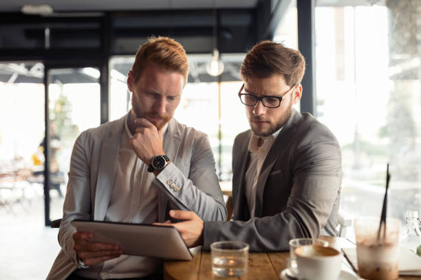 istock Smart businessman wearing suit using tablet in cafe 665025354