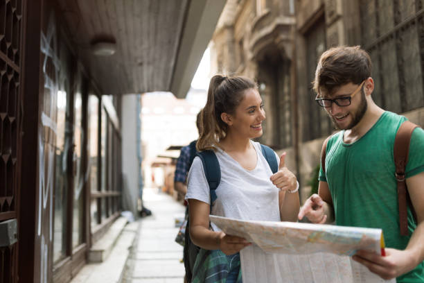istock Young happy tourists holding map sightseeing in city 665028742