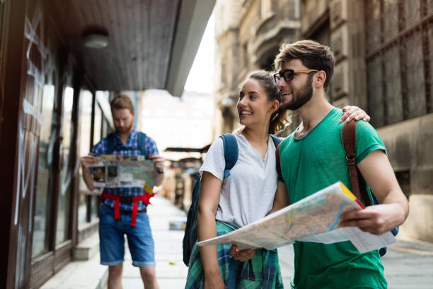 istock Young happy tourists holding map sightseeing in city 665028782