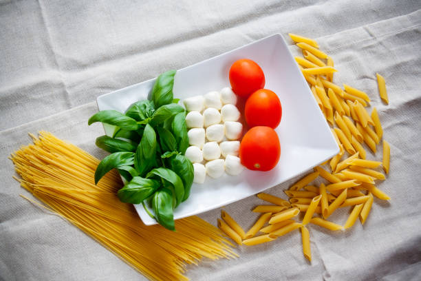 istock Tomatoes, mozzarella, raw pasta and green basil leaves 665031878