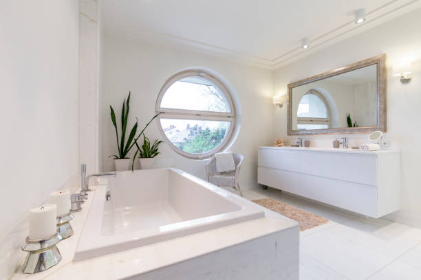 istock Minimalist white bathroom with a circulal window 665037948