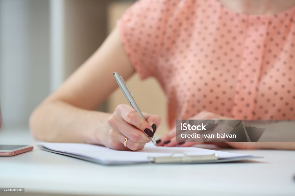 Female student doing homework .With depth of field image Writing - Activity Stock Photo