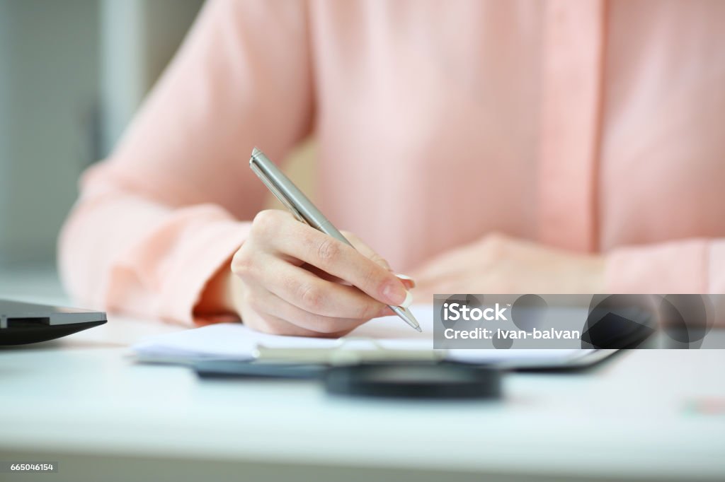 Femme d’affaires tenant un crayon dans sa main et a signé un contrat, avec une profondeur de champ image - Photo de Main libre de droits