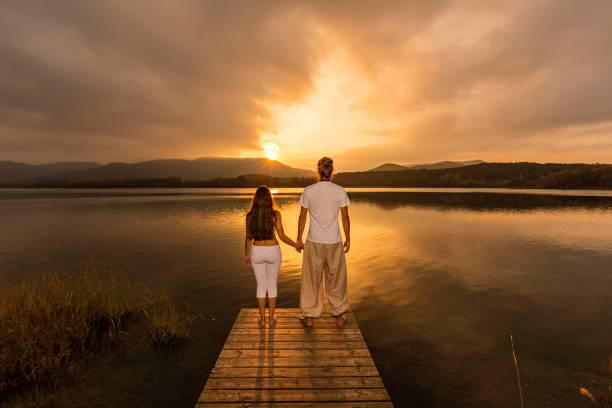 istock Young woman and man looking at sunset 665047464