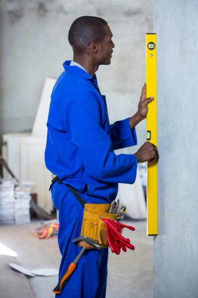 istock Handyman measuring a wall with spirit level 665048048