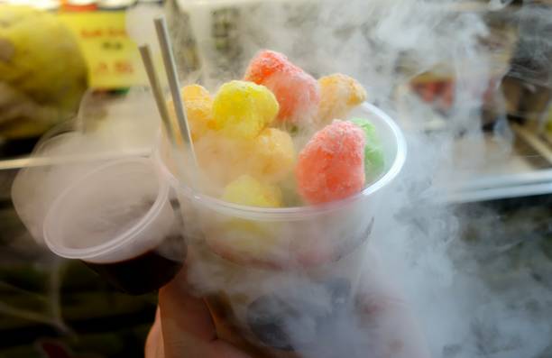 Sweet colored candies with steam of nitrogen liquid in a cup Sweet colored candies with steam of nitrogen liquid in a cup in a market nitrogen stock pictures, royalty-free photos & images