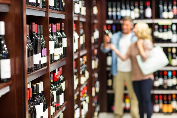 istock Smiling couple looking at bottle of wine 665059462