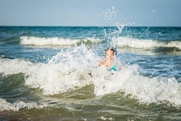 istock Child splashig in sea waves 665067714
