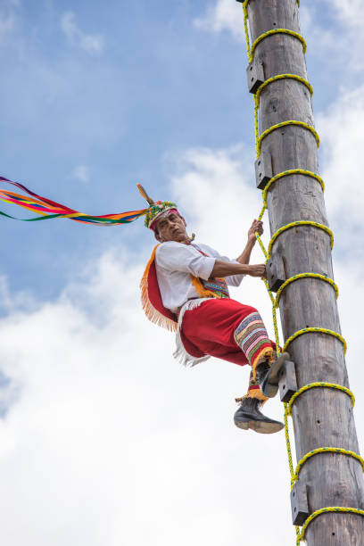 Voladores performing flying men show. Cancun, Mexico - Mar 15, 2017: Traditional flying birdmen performance by voladores: performers throw themselves off a tall wooden pole while rotating towards the ground as part of a ritual ceremony to ask for fertility. volador stock pictures, royalty-free photos & images