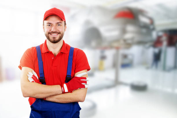 istock happy auto mechanic standing in car service garage 665069194