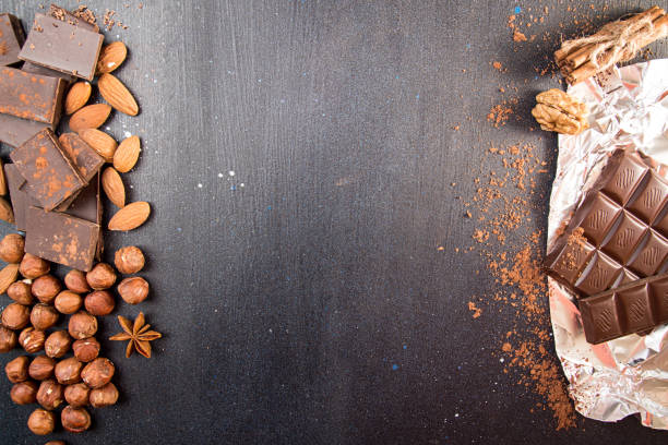 istock Chocolate pieces, filbert, chocolate shavings, walnut on dark background. 665073554