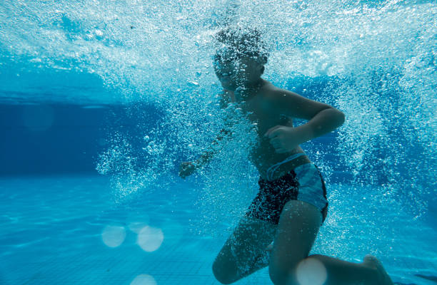 istock Happy young asian kid with swim goggles underwater 665077094
