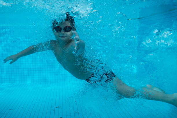 istock Happy young asian kid with swim goggles underwater 665077112