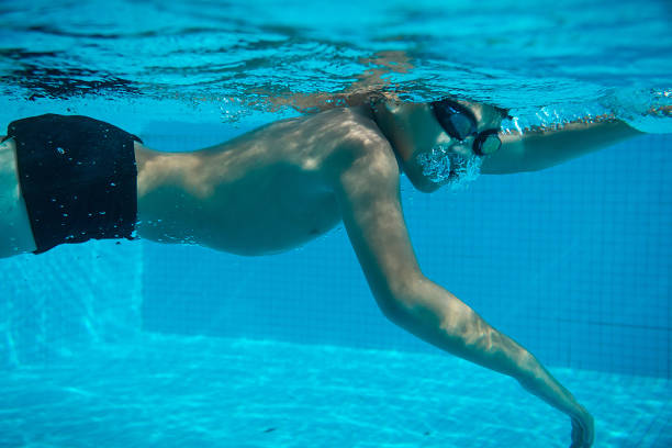 istock Happy young asian kid with swim goggles underwater 665077128