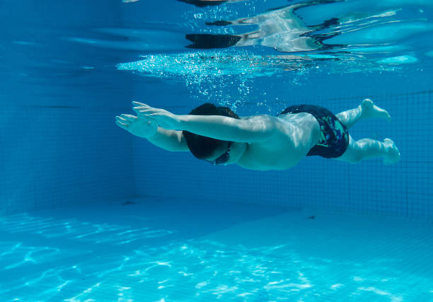 istock Happy young asian kid with swim goggles underwater 665077166
