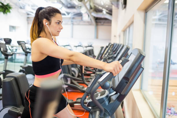 istock Focused woman on the ellipitical machine 665080552