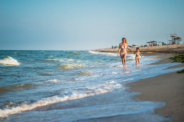 istock Mother with child play at sea shore 665093134