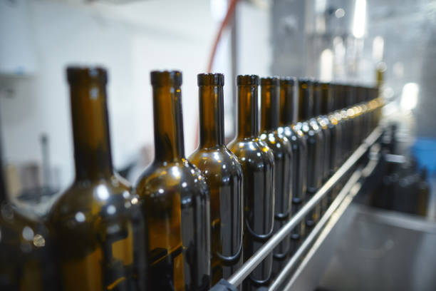 istock Row of wine bottles moving by conveyor 665094016