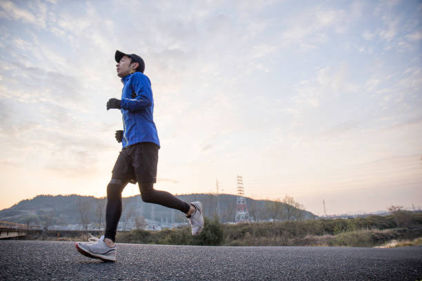 Japanese men running in the morning A landscape where one man runs while taking the morning sun exercise routine stock pictures, royalty-free photos & images