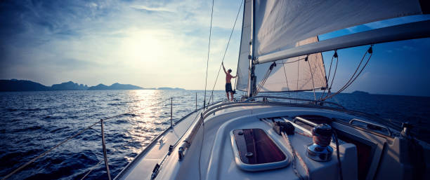 homme sur le yacht - sailboat sunset sailing nautical vessel photos et images de collection