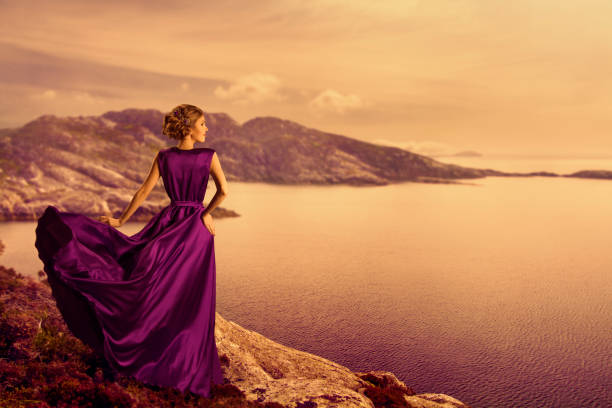 donna in abito elegante sulla costa della montagna, modella in abito scorrevole, guardando lontano - mountain looking at view beach cliff foto e immagini stock