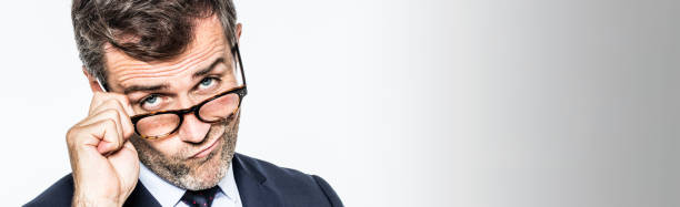 istock long banner for pouting far-sighted businessman moving eyeglasses down 665107458