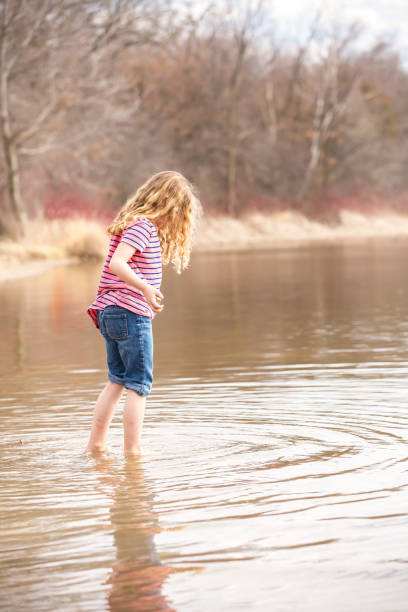 istock Girl Playing in Lake In Early Springtime 665111866