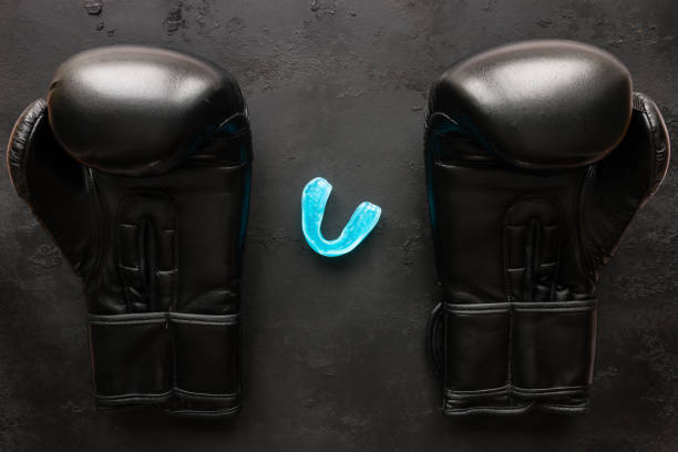 istock Boxing gloves and a mouth guard on a black background 665113332