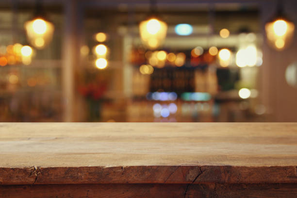 istock wooden table in front of abstract restaurant lights background 665114496