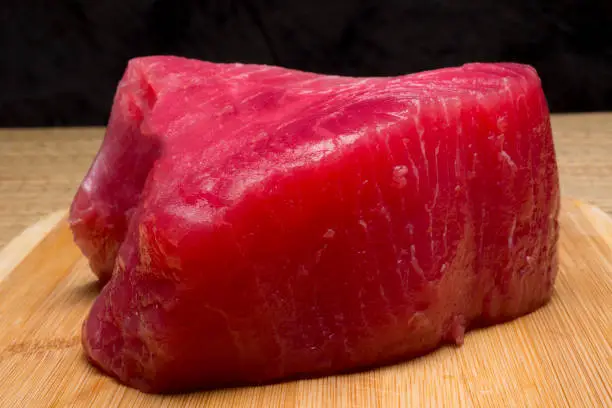 large piece of tuna fish on cutting board