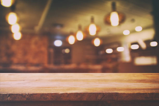 istock wooden table in front of abstract restaurant lights background 665117326
