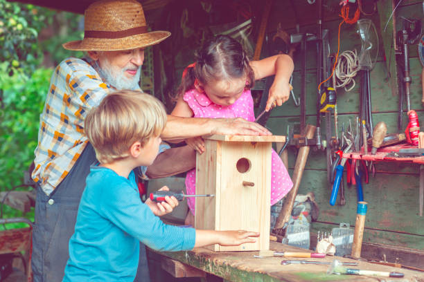 istock Grandpa with children make birdhouse 665117830