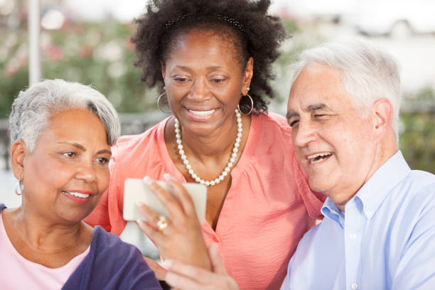 istock Multi-ethnic group of senior adult friends using technology at cafe. 665124914