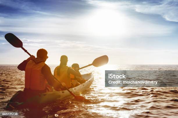 Familia De Padre Madre E Hijo Kayak Al Atardecer De Mar Foto de stock y más banco de imágenes de Familia