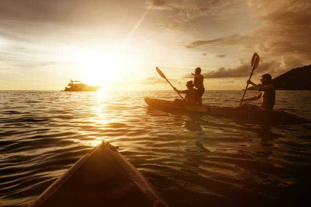 istock Two kayaks with family at sunset sea 665131482