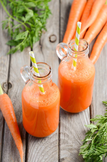 istock Fresh carrot juice in a bottles on rustic wooden background. 665132252
