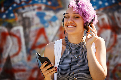 Hipster girl with headphones listening to music outdoor