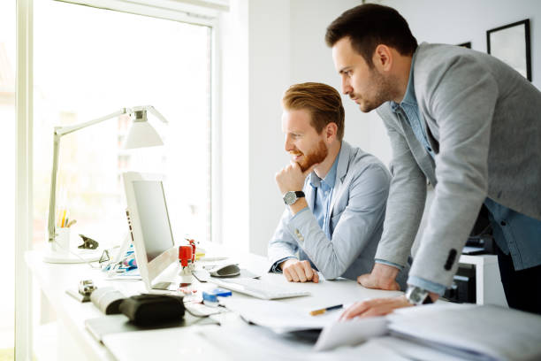 istock Coworkers working on project together in office 665136260